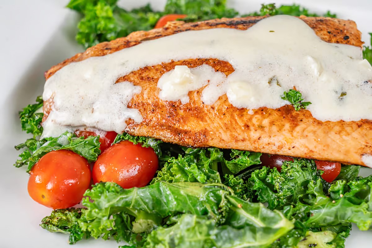 Fresh salmon over a bed of greens with tomatoes